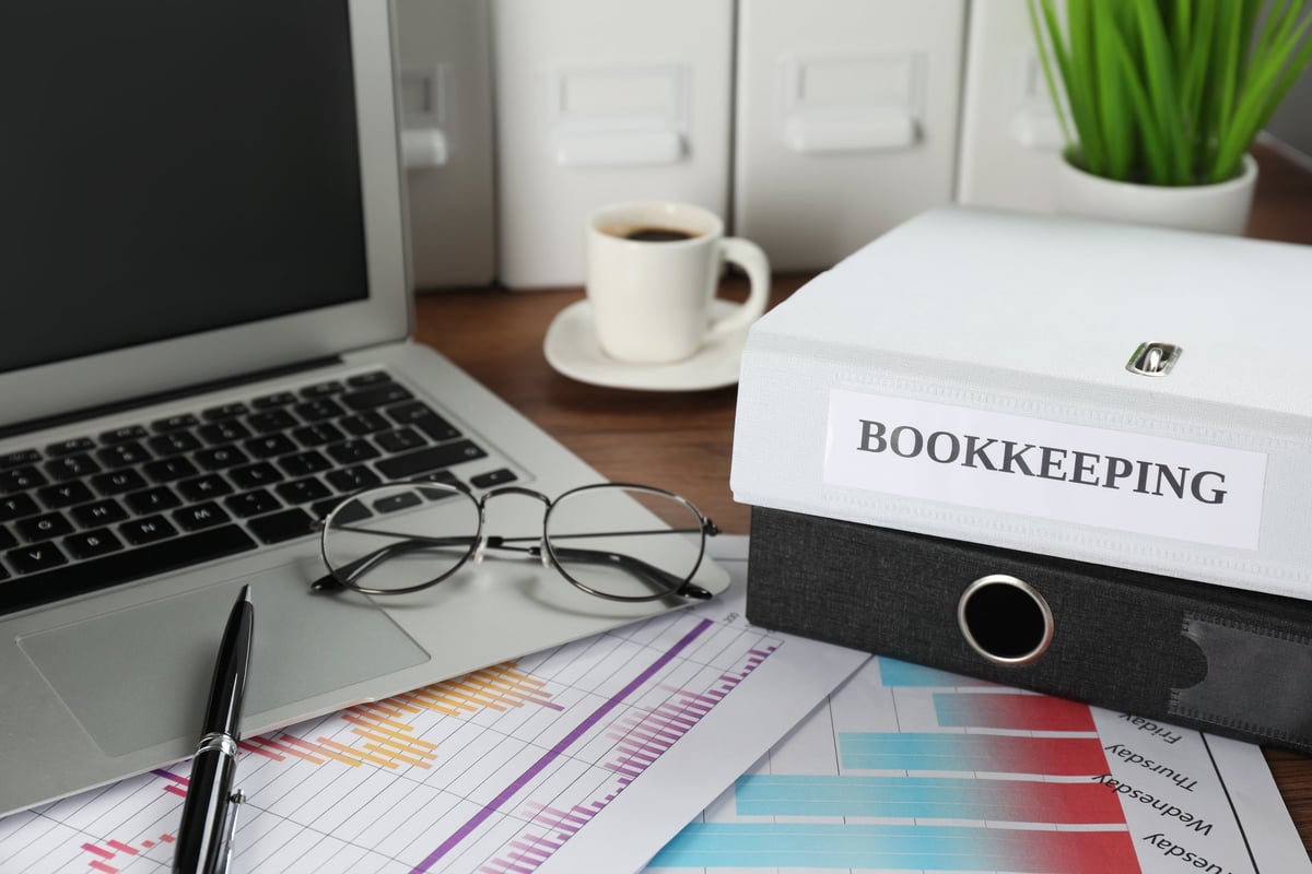Folders, laptop and documents on an office desk — a bookkeeper's workspace
